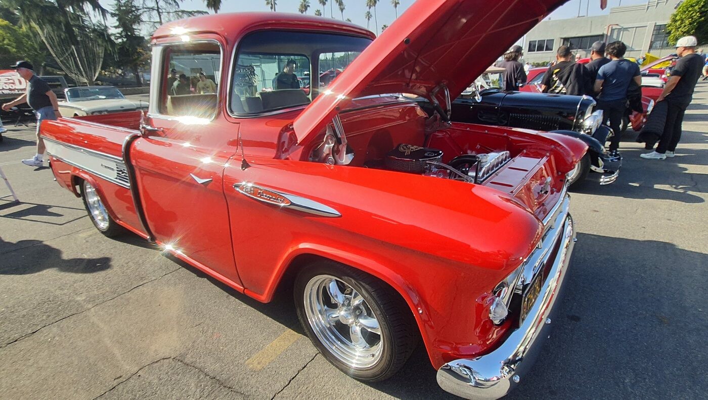 Czerwony Chevrolet 3100 fleetside z 1957 roku z otwartą maską – pickup Task Force na polerowanych felgach