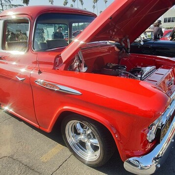 Czerwony Chevrolet 3100 fleetside z 1957 roku z otwartą maską – pickup Task Force na polerowanych felgach