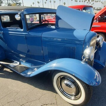 Niebieski Ford Model A Tudor sedan z 1931 roku z otwartą maską – przedwojenny sedan na białych ściankach