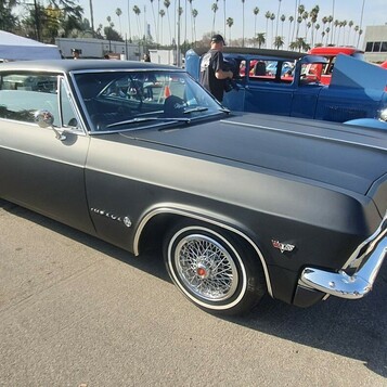 Satynowo-czarny Chevrolet Impala z 1965 roku z otwartą maską – lowrider na drucianych felgach