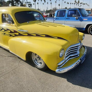 Żółty Chevrolet sedan delivery z 1948 roku z czarnymi płomieniami – firmowa furgonetka jako kustom