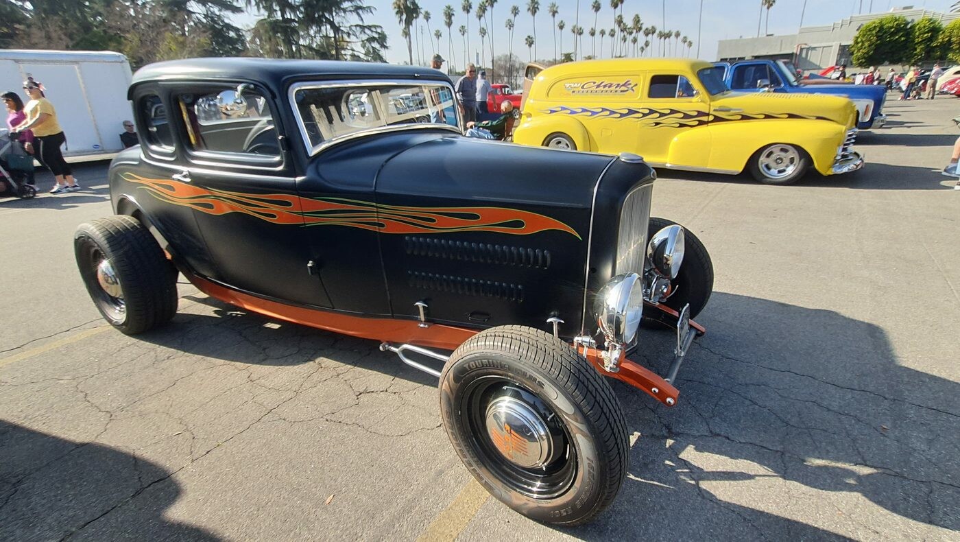 Czarny Ford 5-window coupe z 1932 roku w pomarańczowych płomieniach – tradycyjny chopped Deuce na czarnych felgach
