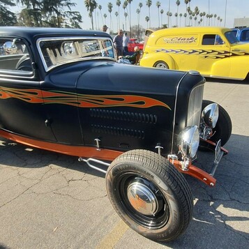 Czarny Ford 5-window coupe z 1932 roku w pomarańczowych płomieniach – tradycyjny chopped Deuce na czarnych felgach