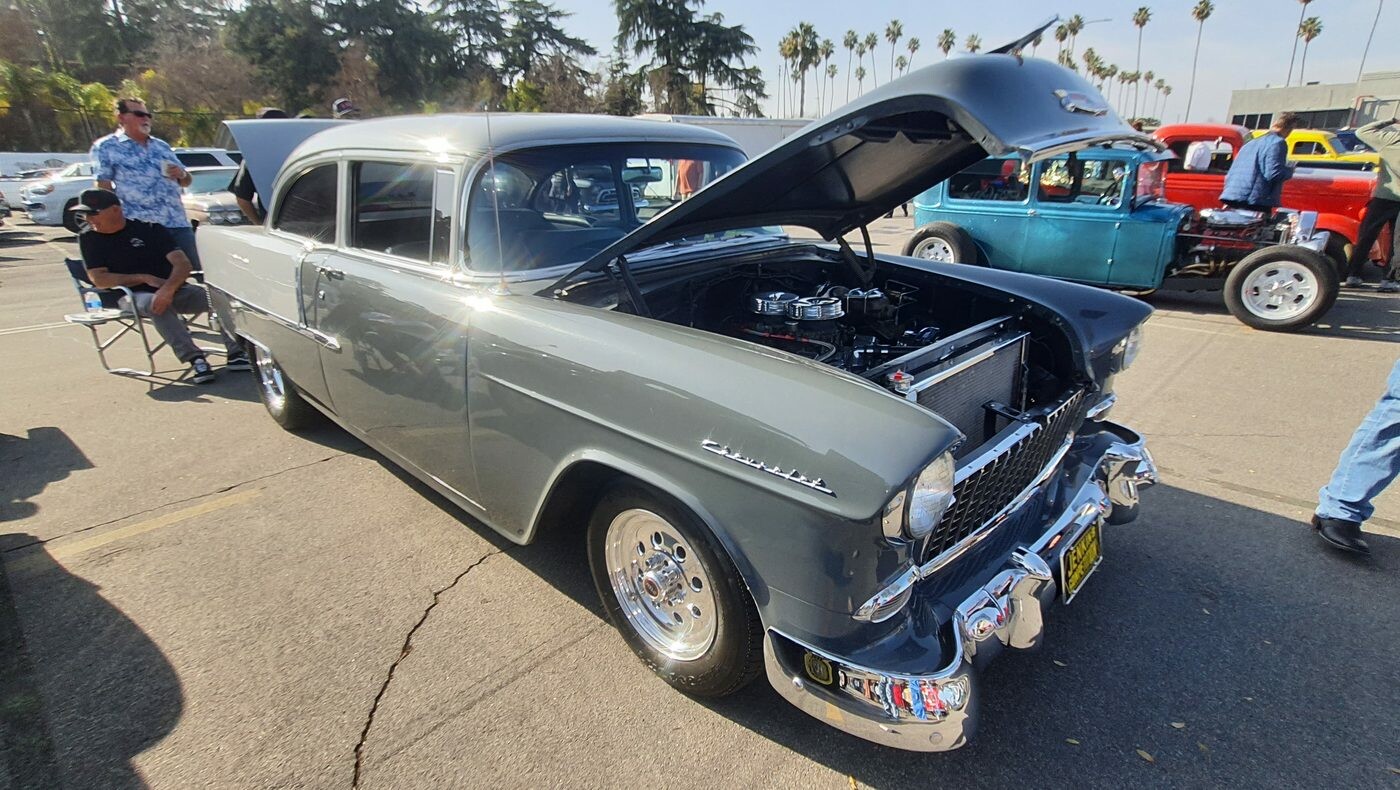 Szary Chevrolet 210 z 1955 roku z otwartą maską – dwudrzwiowy sedan na polerowanych felgach