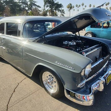 Szary Chevrolet 210 z 1955 roku z otwartą maską – dwudrzwiowy sedan na polerowanych felgach