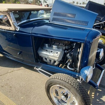 Granatowy Ford roadster z 1932 roku z beżowym dachem i otwartą maską – Deuce highboy z żaluzjami