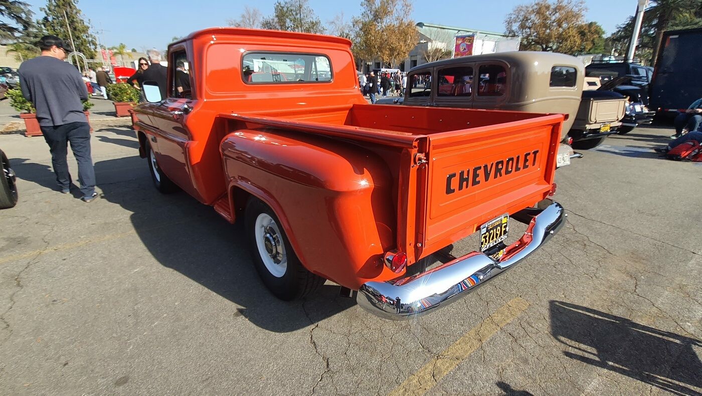 Czerwony Chevrolet 3100 stepside z 1958 roku od tyłu – klapa z napisem CHEVROLET i białe ścianki