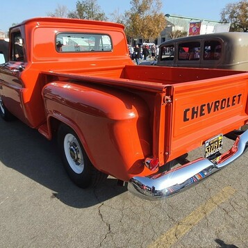 Czerwony Chevrolet 3100 stepside z 1958 roku od tyłu – klapa z napisem CHEVROLET i białe ścianki