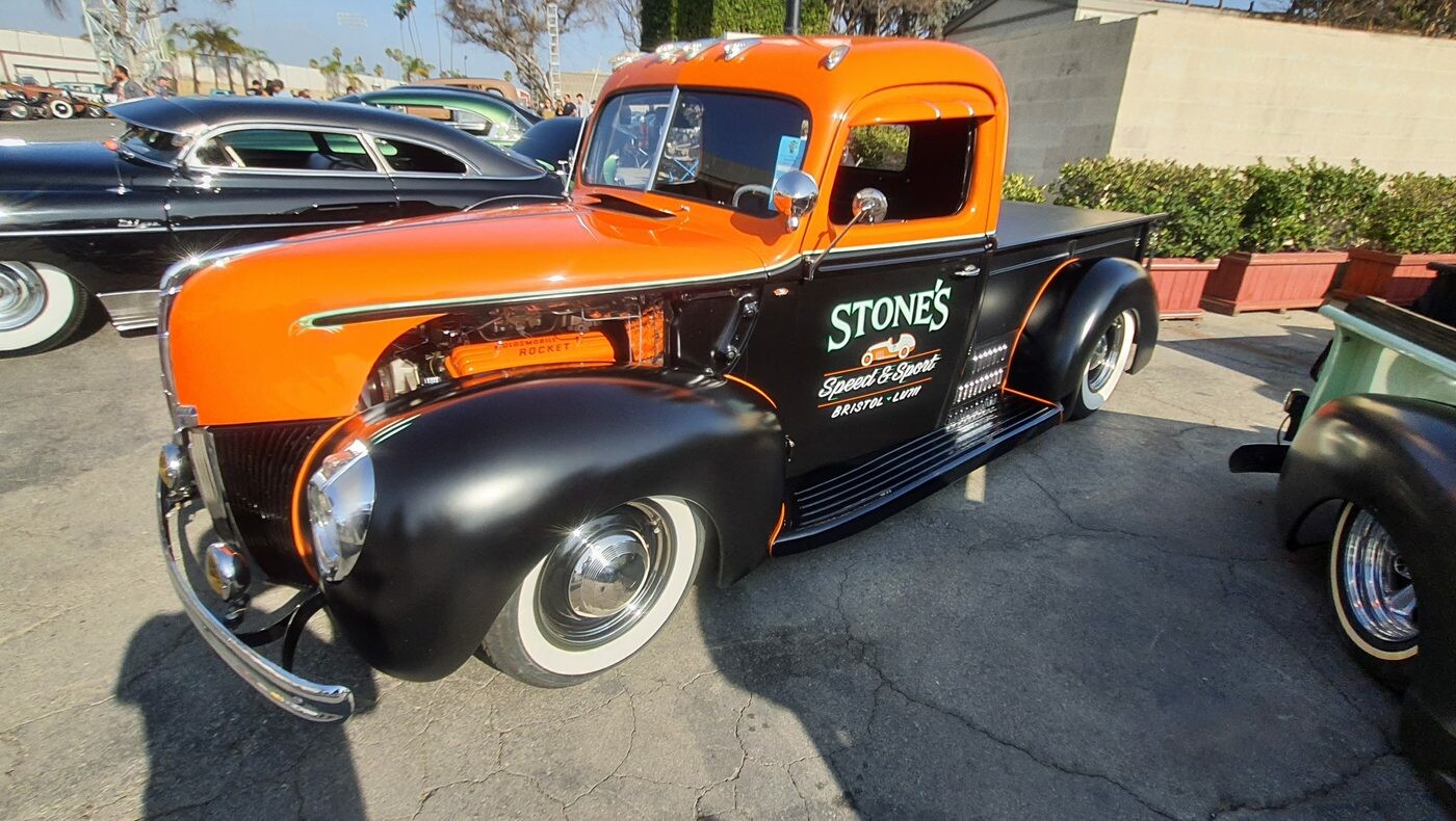 Pomarańczowo-czarny Ford pickup z 1941 roku z napisem warsztatu – firmowa ciężarówka jako kustom