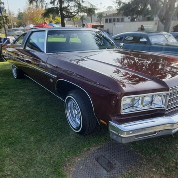 Bordowy Chevrolet Caprice Classic z 1976 roku – wielkie coupe z prostokątnymi reflektorami na drucianych kołpakach