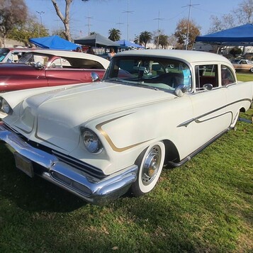 Biały Chevrolet 210 z 1956 roku jako mild kustom – wtopione reflektory, rurowa atrapa i złote scallopsy