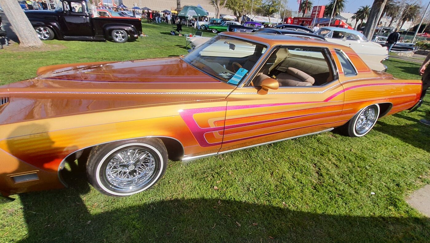 Złoto-pomarańczowy Chevrolet Monte Carlo z 1979 roku lowrider – pasy, koronka i druciane felgi
