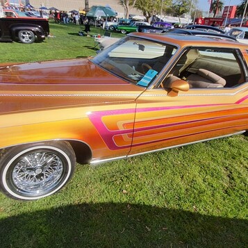 Złoto-pomarańczowy Chevrolet Monte Carlo z 1979 roku lowrider – pasy, koronka i druciane felgi