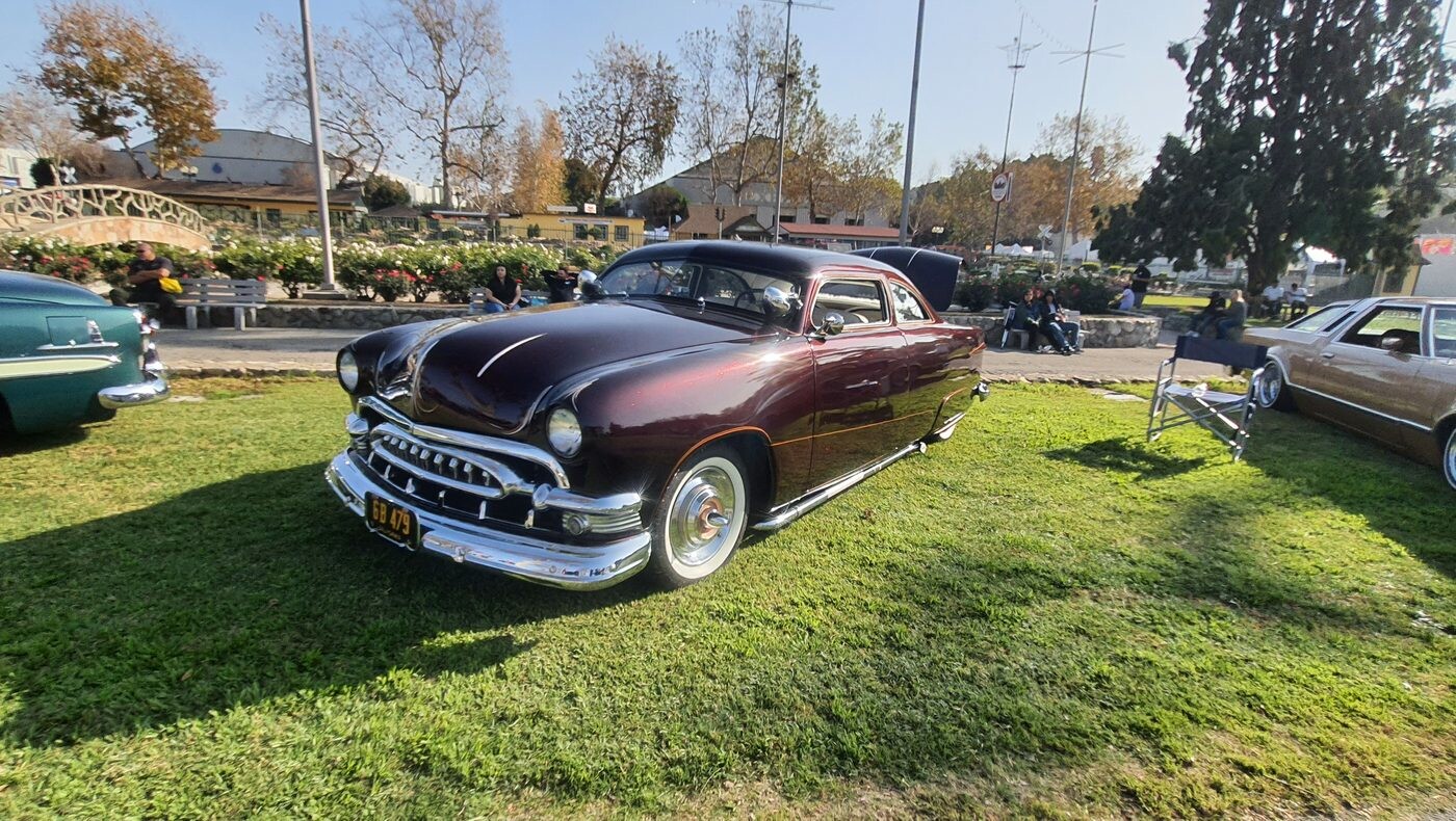 Ford shoebox z 1950 roku w kolorze czarnej wiśni – obniżony kustom z chromowaną atrapą na białych ściankach