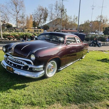 Ford shoebox z 1950 roku w kolorze czarnej wiśni – obniżony kustom z chromowaną atrapą na białych ściankach