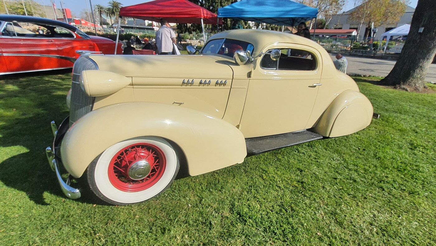 Kremowy Buick Special coupe z 1936 roku na czerwonych drucianych kołach – przedwojenna elegancja