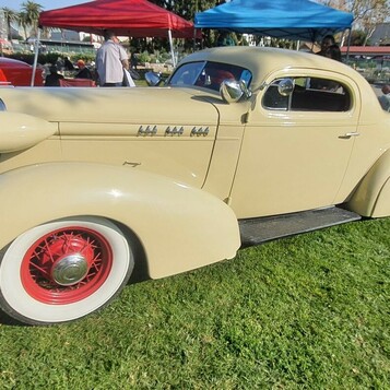 Kremowy Buick Special coupe z 1936 roku na czerwonych drucianych kołach – przedwojenna elegancja