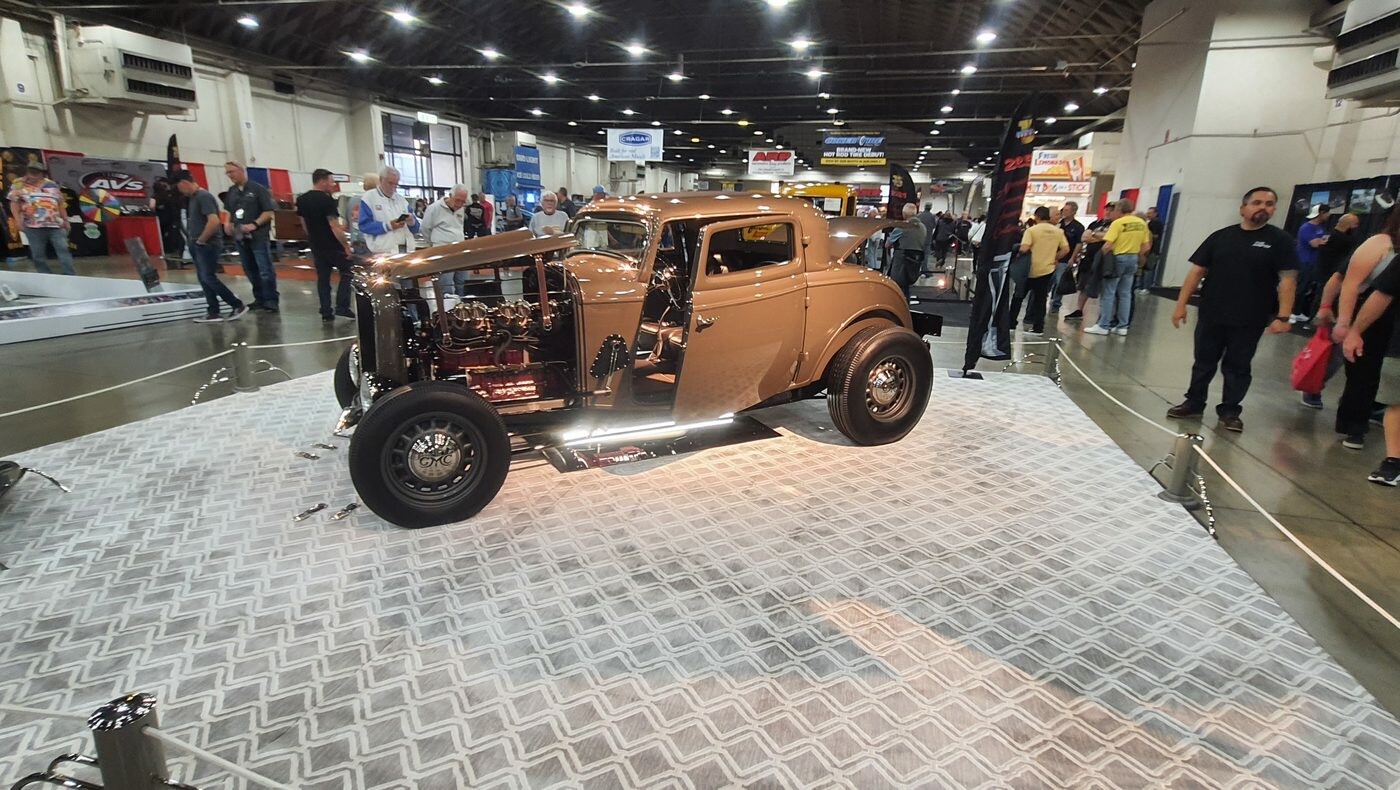 Miedziany Ford 3-window coupe z 1932 roku w hali – highboy na wzorzystej podłodze wystawowej