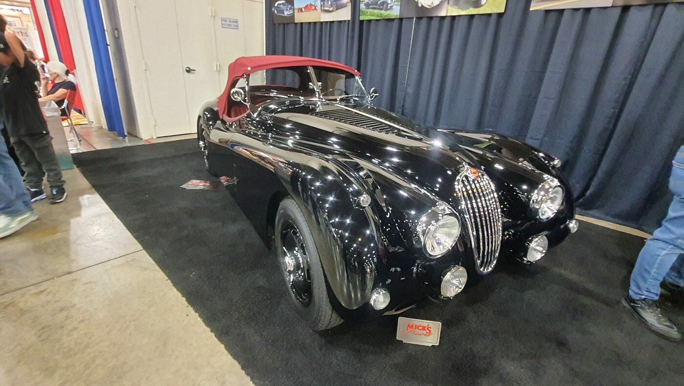 Czarny Jaguar XK120 roadster z czerwonym dachem – brytyjski klasyk lat 50. w hali zlotu