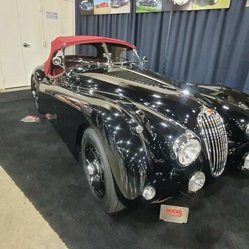 Czarny Jaguar XK120 roadster z czerwonym dachem – brytyjski klasyk lat 50. w hali zlotu