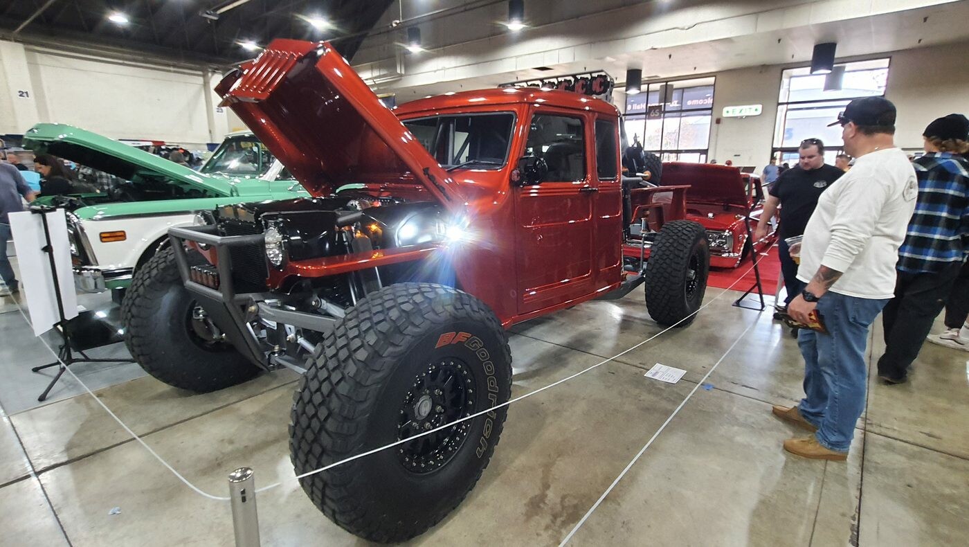 Czerwony Dodge Power Wagon crew cab z lat 70. na wielkich oponach – terenowy pickup z otwartą maską w hali