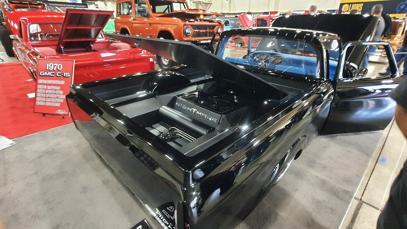 Czarny GMC C15 z 1970 roku w hali – pickup restomod z otwartą maską i skrzynią wykończoną jak nadwozie