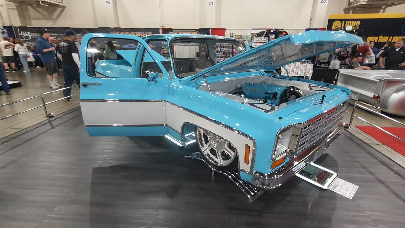 Błękitno-biały Chevrolet C10 square body z kompresorem – otwarta maska i drzwi na wystawie