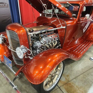 Pomarańczowy Ford 5-window coupe z 1932 roku w candy z chromowanym silnikiem – Deuce na złotych felgach w hali
