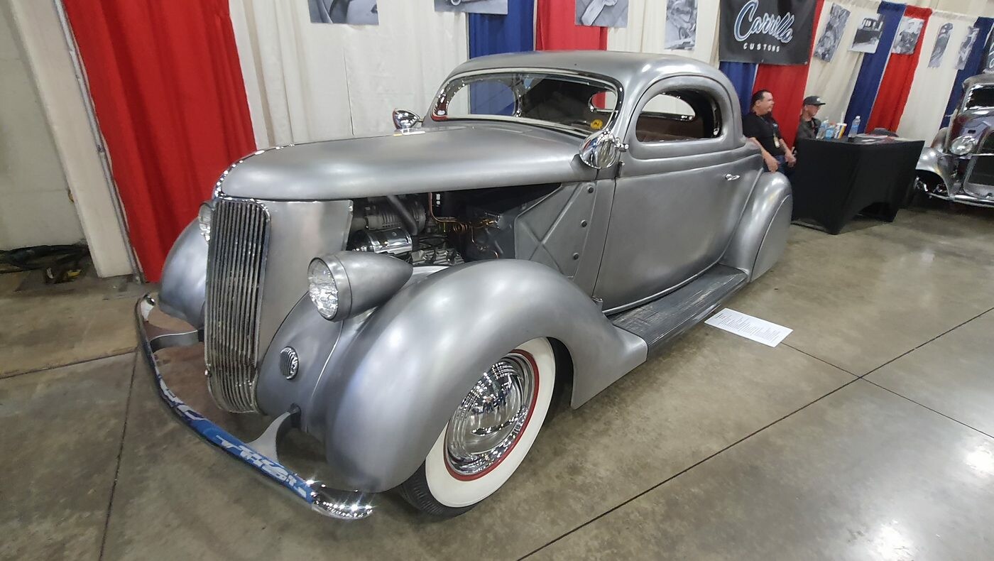 Srebrny satynowy Ford 3-window coupe z 1936 roku – chopped kustom w matowym metalu na białych ściankach