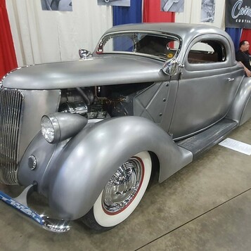 Srebrny satynowy Ford 3-window coupe z 1936 roku – chopped kustom w matowym metalu na białych ściankach