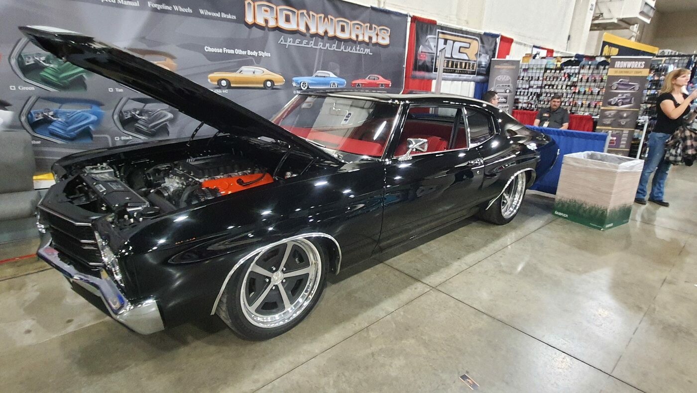 Czarny Chevrolet Chevelle SS z 1970 roku z otwartą maską – pomarańczowy big block na stoisku w hali