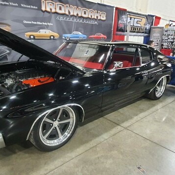 Czarny Chevrolet Chevelle SS z 1970 roku z otwartą maską – pomarańczowy big block na stoisku w hali