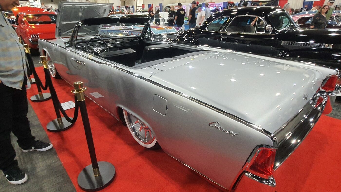 Srebrny Lincoln Continental kabriolet z 1963 roku z otwartym dachem – drzwi „samobójcze” za aksamitnymi sznurami