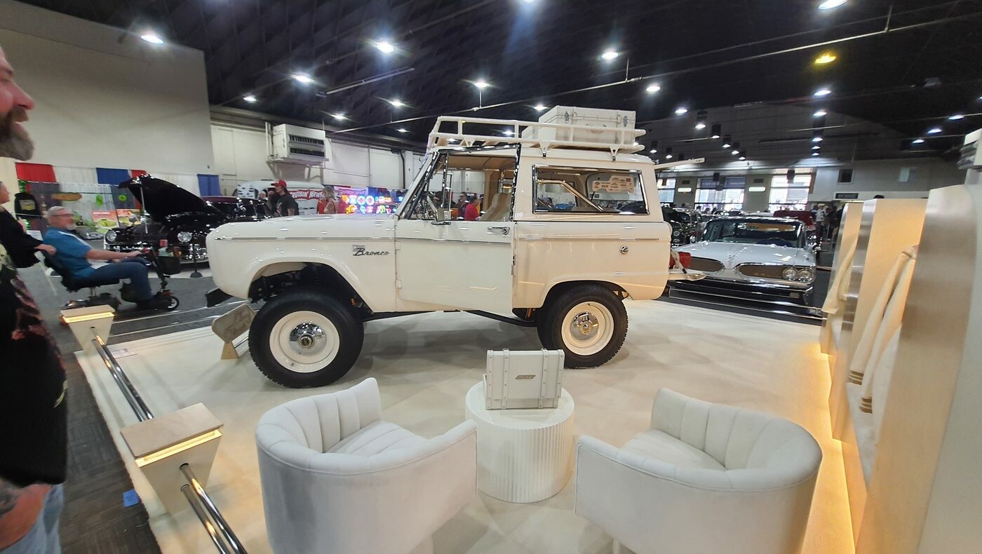 Biały Ford Bronco pierwszej generacji z bagażnikiem dachowym – terenówka na białym stoisku z fotelami