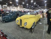 Żółty Ford kabriolet z 1940 roku z opuszczonym dachem – przedwojenny cabriolet z przodu i z tyłu w hali zlotu – zdjęcie 1