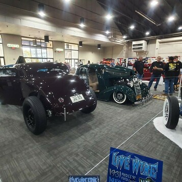 Śliwkowy Ford 3-window coupe z 1934 roku chopped w hali – tradycyjny hot rod na czarnych felgach