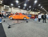 Pomarańczowy Willys coupe z 1941 roku street rod – z przodu i z tyłu za sznurem w hali zlotu – zdjęcie 1
