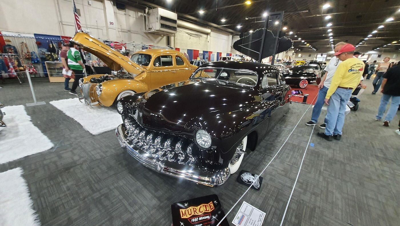Śliwkowy Mercury z 1951 roku chopped z zębatą atrapą – lead sled na białym „śniegu” z otwartą maską w hali