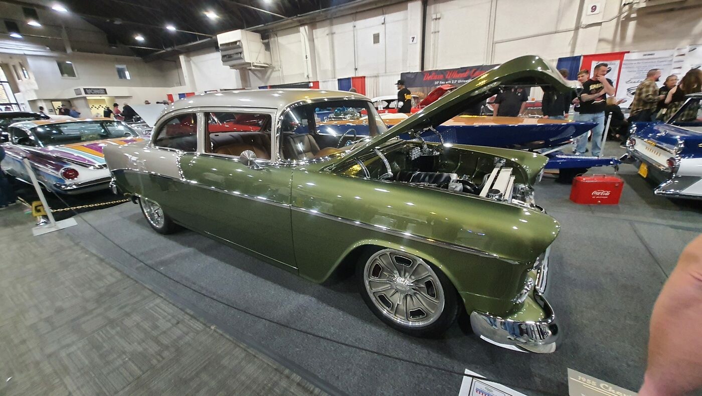 Oliwkowy Chevrolet 210 z 1955 roku z otwartą maską – dwudrzwiowy sedan w zieleni metalik na polerowanych felgach