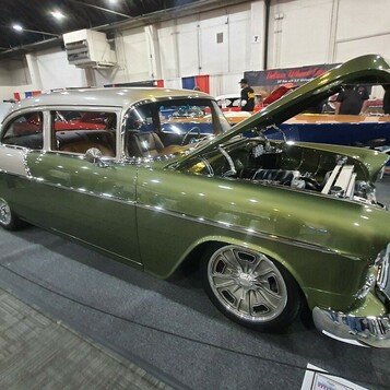 Oliwkowy Chevrolet 210 z 1955 roku z otwartą maską – dwudrzwiowy sedan w zieleni metalik na polerowanych felgach