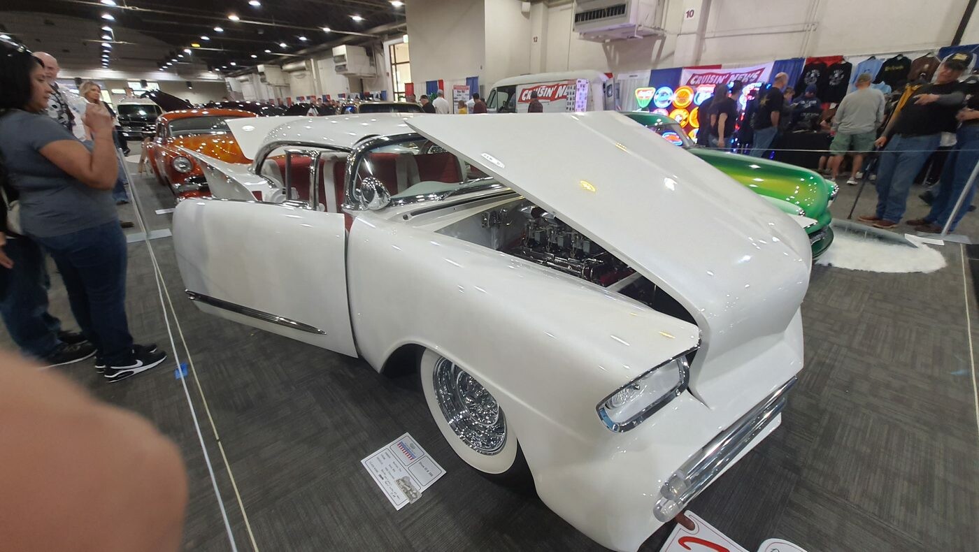 Biały Chevrolet El Camino z 1959 roku lowrider z otwartą maską – skrzydła, druciane felgi i biel w hali