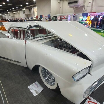 Biały Chevrolet El Camino z 1959 roku lowrider z otwartą maską – skrzydła, druciane felgi i biel w hali