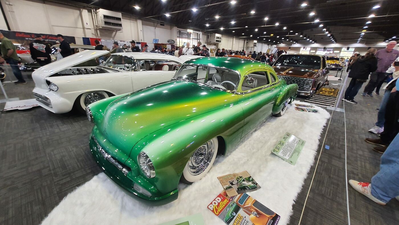 Zielony Chevrolet Fleetline z 1950 roku lowrider w lakierze fade – od limonki po butelkową zieleń na drucianych felgach