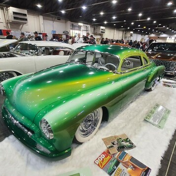 Zielony Chevrolet Fleetline z 1950 roku lowrider w lakierze fade – od limonki po butelkową zieleń na drucianych felgach