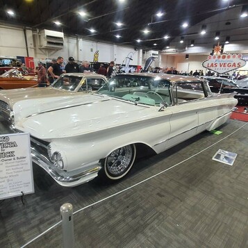 Biały Buick Invicta kabriolet z 1960 roku lowrider – wielki otwarty Buick na drucianych felgach w hali