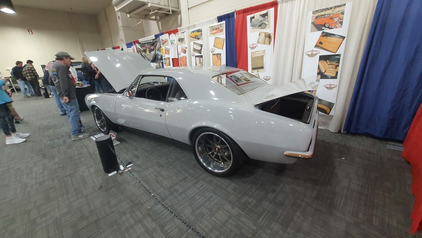 Szary Pontiac Firebird z 1967 roku pro touring na stoisku tapicera – otwarta maska i bagażnik w hali