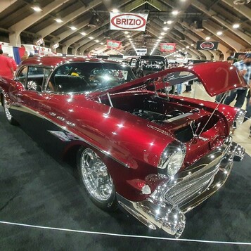 Czerwony candy Chevrolet Bel Air z 1957 roku z otwartą maską – „57 Chevy” klasy show z przodu i z boku