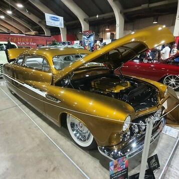 Złoty candy Chevrolet Fleetline z 1951 roku chopped z otwartą maską – fastback kustom w głównej hali