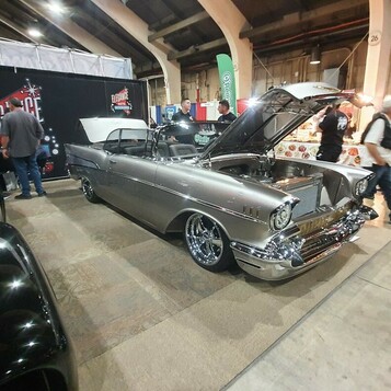 Srebrny Chevrolet Bel Air z 1957 roku z otwartą maską – „57 Chevy” w metaliku na polerowanych felgach w hali