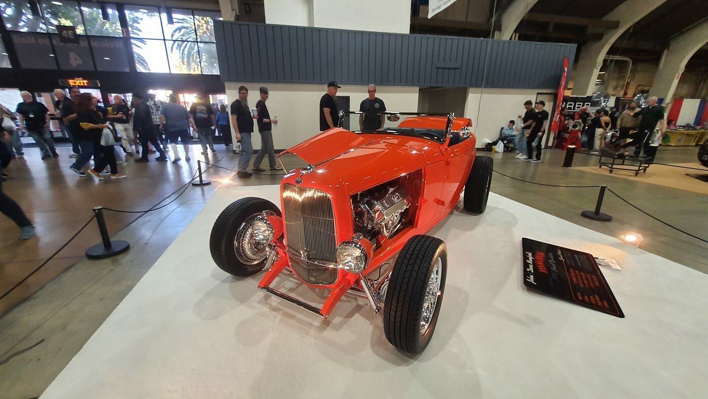 Pomarańczowy Ford roadster z 1932 roku z chromowanym silnikiem – pretendent do nagrody AMBR na białym dywanie